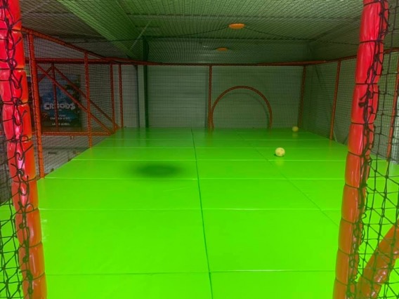 Le terrain de foot grillagé, au sol vert