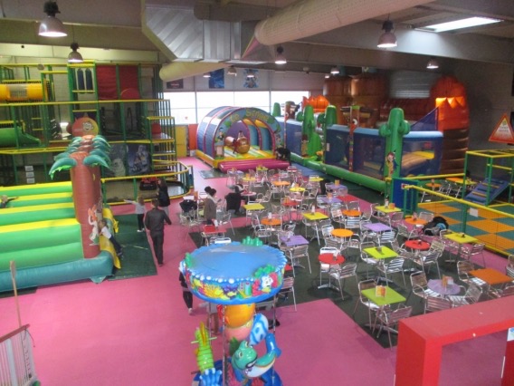 La salle de Jumpi vue d'en haut : gonflables, labyrinthe et tables